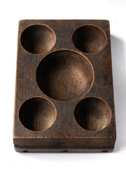 A very handsome Edwardian coin organiser that would have once stood on a grocery store counter - as a handy dispenser for small change. Carved from a single block of oak, with three hollowed-out half-spheres, it has been&nbsp;polished smooth from its years of use, and has developed a wonderful hand-worn patina. Its shop work days may be over, yet it still makes a great organiser - for change, keys, or for all those bits and pieces that accumulate in the kitchen or on the desk.