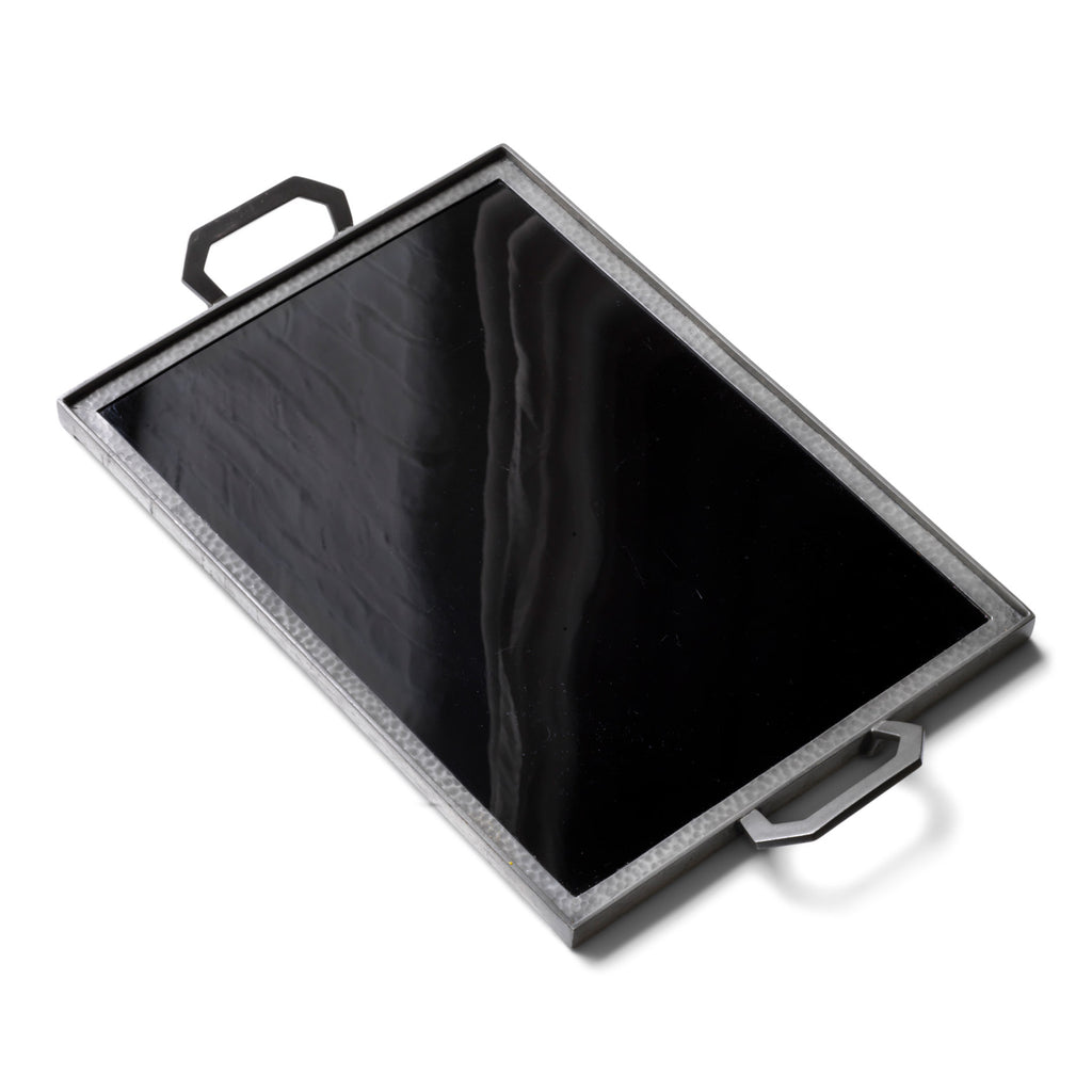 A stunning 1930s Art Deco black Vitrolite glass and hammered pewter tray. The rectangle of black glass is mounted flush in a pewter frame that is held by a pair of art deco shaped pewter handles.