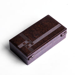 A striking 1930s Bakelite box with a hinged lid applied with a press-moulded modernist motif, and with "Made in England" to its underside. Its stepped and streamlined rounded edges make it a good example of early twentieth century Art Deco influenced Modernism.