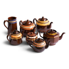 A collection of vintage Brown Betty teapots with coloured and marbled banding and a Sadler jug.