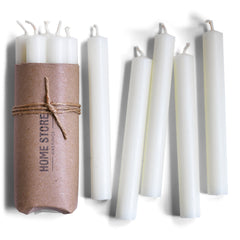 Bundle of church candles containing beeswax wrapped in brown paper and  tied with string.