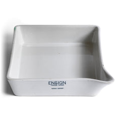 A ceramic ironstone photographic developing tray with pouring lip, made by Ensign, a Victorian manufacturer of porcelain darkroom products. Today it can be repurposed for kitchen use, or as a stand for plants. The makers stamp can be seen on the front end of the tray.
