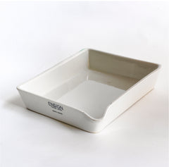 A ceramic ironstone photographic developing tray with pouring lip, made by Ensign, a Victorian manufacturer of porcelain darkroom products. Today it can be repurposed for kitchen use, or as a stand for plants. The makers stamp can be seen on the front end of the tray.