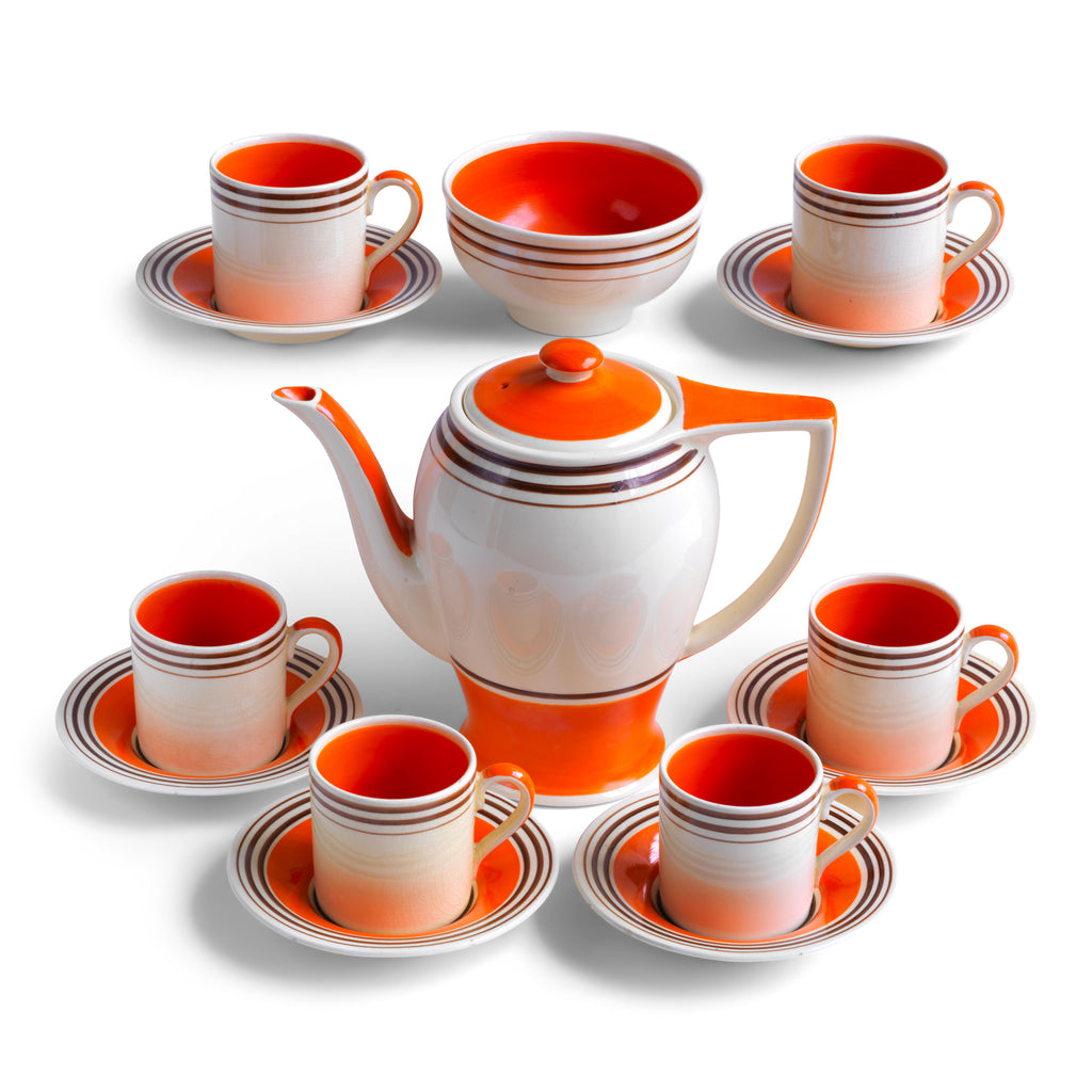 A stunning 1930s Art Deco Susie Cooper coffee set in her classic Rex shape with tango orange banding. The Susie Cooper trademark signature is on the underside of each piece, and the set includes a coffee pot, sugar bowl, and six cans & saucers - and all in wonderful condition.