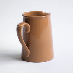 A 920s stoneware cream jug glazed in camel brown and with "Dudson Hanley England Vitrified Stoneware" stamped on its base.
