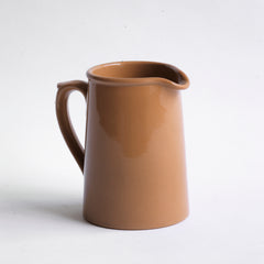 A 920s stoneware cream jug glazed in camel brown and with "Dudson Hanley England Vitrified Stoneware" stamped on its base.