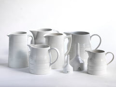 A collection of good late nineteenth century and early twentieth century ironstone and creamware water jugs and funnels