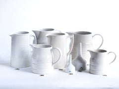 A collection of good late nineteenth century and early twentieth century ironstone and creamware water jugs and funnels