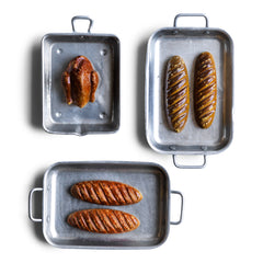 A charming collection of vintage doll's house bloomer style loaves with slashed baked tops; a set of aluminium baking / roasting pans with handles; and a fat little burnished roast chicken - all with their original painted finish, and modelled from a composition plaster material.