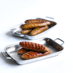 A charming collection of vintage doll's house bloomer style loaves with slashed baked tops; a set of aluminium baking / roasting pans with handles; and a fat little burnished roast chicken - all with their original painted finish, and modelled from a composition plaster material.