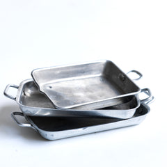 A charming collection of vintage doll's house bloomer style loaves with slashed baked tops; a set of aluminium baking / roasting pans with handles; and a fat little burnished roast chicken - all with their original painted finish, and modelled from a composition plaster material.