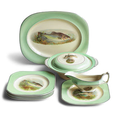 A glorious 1930s fish dinner service, complete with a large platter for serving a whole fish.  Each piece is embellished with a fresh water fish, such as pike, perch and trout, and contained within a mint-green border. Each item is stamped "Woods Ivory Ware England" to its underside.