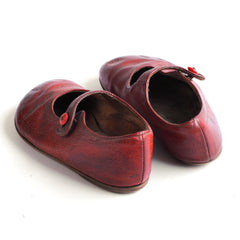 A dear little pair of vintage red leather baby's first shoes, complete with their original fastening buttons, and with leather soles, dating from 1930s - 1950.