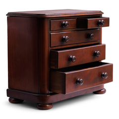 A pleasingly proportioned Victorian mini chest of drawers with rounded corners and bun feet. Comprising of three long and two short drawers, each retaining its original pair of turned wooden knobs.