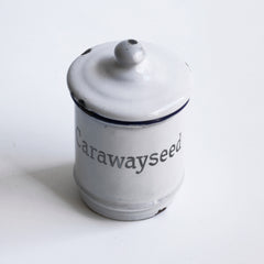 A rare and charming little enamel caraway seed canister with grey typeface, blue rim and original lid.  Year of manufacture: c.1930  Origin: England   Material: enamelware  Height: 10.5cm  Diameter: 7cm