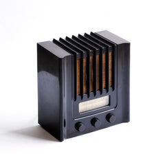 The British Murphy 4 valve AD 94  radio with distinctive Art Deco black Bakelite cabinet was manufactured from 1940.  Looking like a modernist building, this pioneering architectural style  radio resembles a powerhouse of electronic communications. Its streamline, futuristic mirrors  the Machine Age of the late 1930s.. Designed by Eden Minns  in 1940.