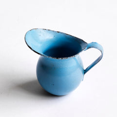 A miniature enamel jug, part of an extensive collection of pale blue enamel miniature antique kitchen ware, previously owned by the miniaturist specialist and collector extraordinaire Joan Dunk; including, flour scoops, sieve, ewer, grater, saucepan, frying pan and a funnel. 