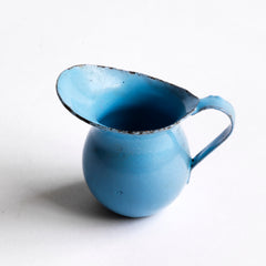 A miniature enamel jug, part of an extensive collection of pale blue enamel miniature antique kitchen ware, previously owned by the miniaturist specialist and collector extraordinaire Joan Dunk; including, flour scoops, sieve, ewer, grater, saucepan, frying pan and a funnel.