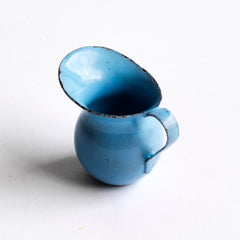 A miniature enamel jug, part of an extensive collection of pale blue enamel miniature antique kitchen ware, previously owned by the miniaturist specialist and collector extraordinaire Joan Dunk; including, flour scoops, sieve, ewer, grater, saucepan, frying pan and a funnel.