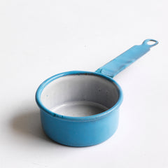 A miniature blue enamel saucepan, part of an extensive collection of pale blue enamel miniature antique kitchen ware, previously owned by the miniaturist specialist and collector extraordinaire Joan Dunk; including, flour scoops, sieve, ewer, grater, saucepan, frying pan and a funnel.