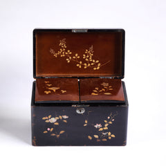 A charming 1920s Japanese lacquered tea caddy inlaid with mother of pearl flowers, leaf sprigs, vine trails, and birds. The bow-topped hinged lid opens up to reveal a further two lacquered boxes with hinged lids which are removable, as shown in the images. Length 23cm Depth 12.5cm Height 14cm.