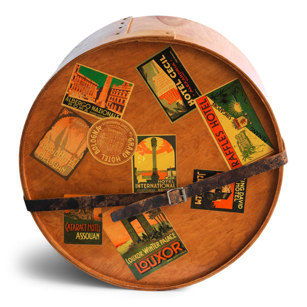 A very impressive Edwardian ply hat box with original luggage stickers and leather strap. The stickers document the owner's grand tours of Italy and Egypt, from the Grand Hotel in Bologna to the Albergo Nazionale of Rome; and then in Egypt - the Hotel Cecil Alexandria, and the Luxor Winter Palace Luxor, to the Cataract Hotel of Assouan. There's also an excursion to Singapore with stay at the Raffles Hotel.