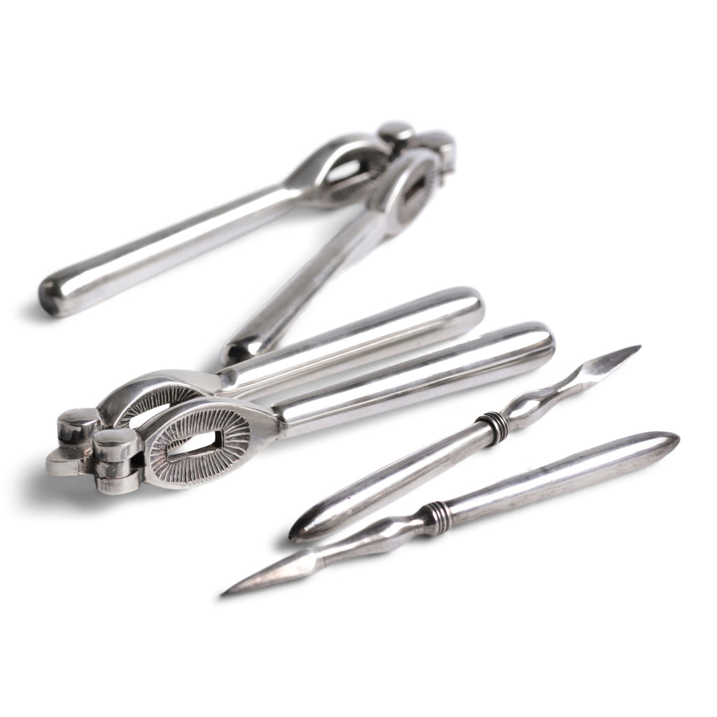 A good boxed set of vintage silver-plated nut crackers and nut picks.  Our vintage silver-plated EPNS (electro-plated nickel silver) nut crackers and picks are both good-looking and functional, and their renewed popularity make them a cool addition on today’s table. Length of nut crackers 14cm Country of origin: UK Date of manufacture: c.1930 Material: EPNS (electro-plated nickel silver) Condition: pristine - probably never used.