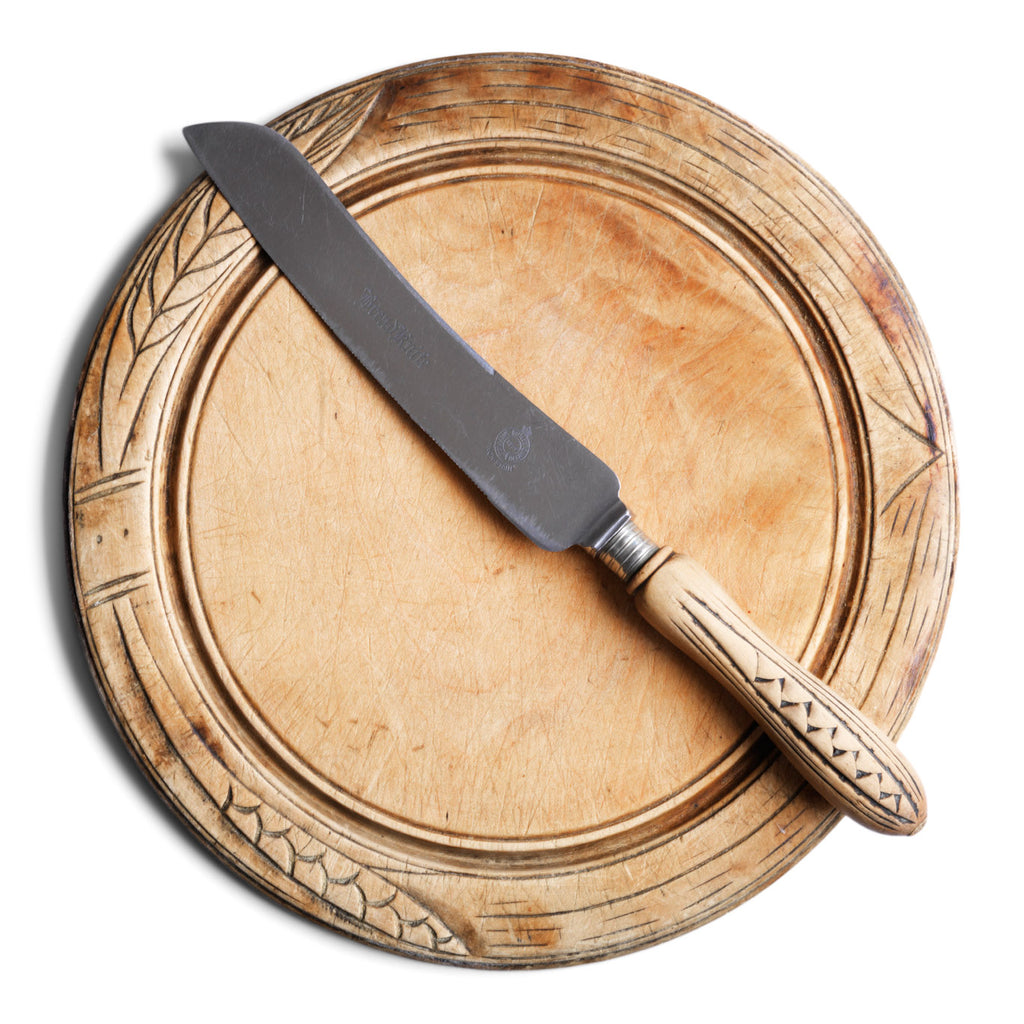 An antique bread board with matching bread knife, each carved with stylised wheat-sheaf motifs. The bread board is of sycamore, richly carved, and sits on a slightly raised foot. The knife has a wheat sheaf patterned handle with "Bread Knife" engraved on its blade; which is fitted to a stainless steel blade, marked "Butler, Sheffield, England". The knife and board have been much loved, and have a wonderful polished patina.