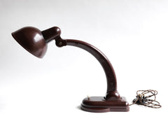 A rare Sigma Bakelite desk lamp designed in the 1940s by Christian Dell at the Bauhaus, Germany, for manufacturer Heinrich Römmler. It has a pivoting arm and adjustable shade for directional lighting, making it ideal for the desk or the bedside table. Constructed of deep chocolate brown Bakelite, it has an on/off switch, and is rewired with cloth covered electrical cable.