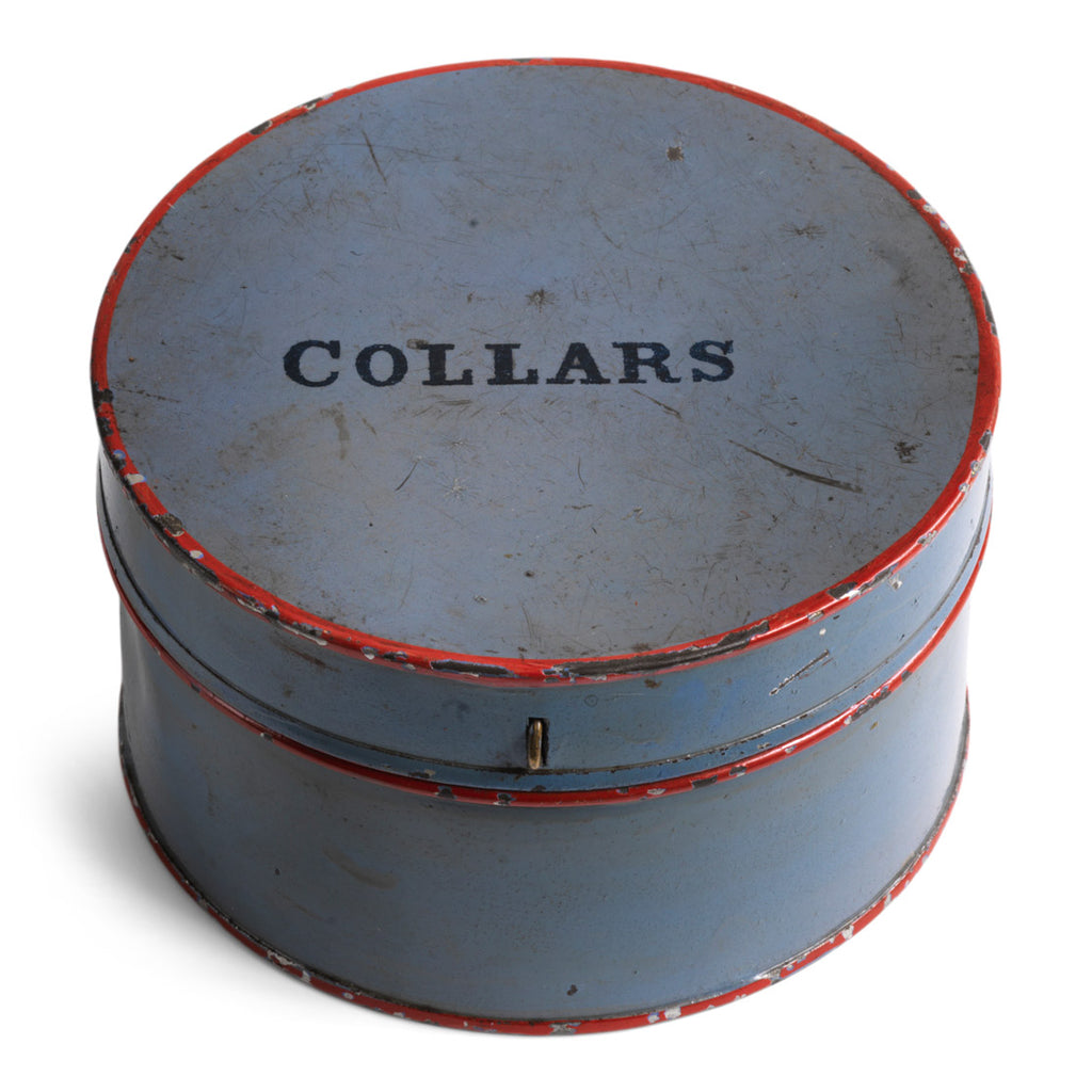 A neat little Edwardian tin collar box with a metallic gold interior and a hinged and fastened lid. The exterior has its original grey painted finish with red trim, and "Collars" in black painted lettering on top. Year of manufacture: c.1900.