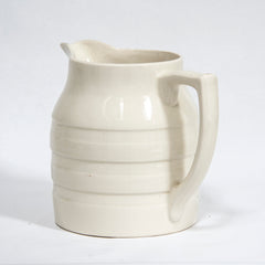 A large 1920s creamware water jug with raised banding and "Sadler England" moulded in relief to the underside of the base.