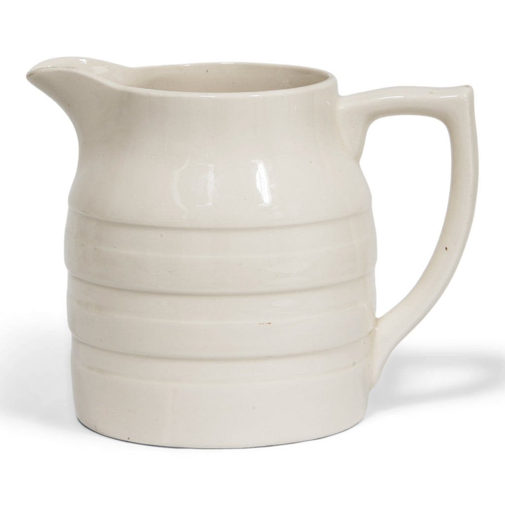 A large 1920s creamware water jug with raised banding and "Sadler England" moulded in relief to the underside of the base.