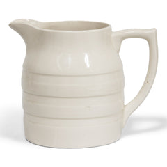 A large 1920s creamware water jug with raised banding and "Sadler England" moulded in relief to the underside of the base.