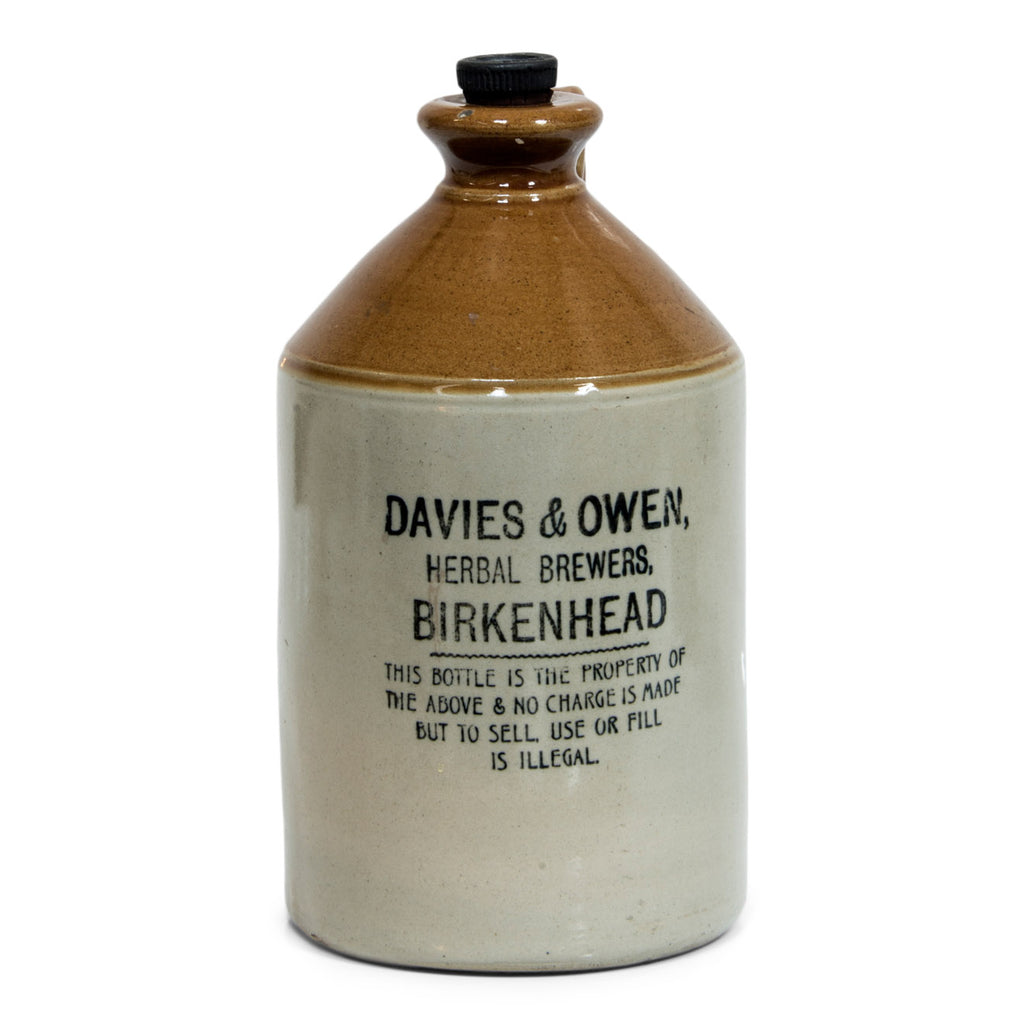 A handsome Victorian flagon with strap handle, original stopper, and bold utilitarian nineteenth century typeface: "Davies & Owen, Herbal Brewers, Birkenhead - this bottle is the property of the above and no charge is made, but to sell, use or fill is illegal".