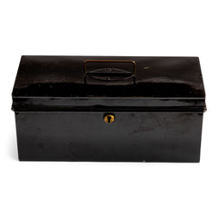 A handy little tin and of beautiful proportion retailed by the grand department store Gamages of London, and with its original black laquered paint finish. Inside the hinged lid is affixed an oval gold plaque embossed with “Trunk & Bag Department - A W Gamage Ltd, Holborn, London EC1”. It has a simple carrying handle and lock with original key.