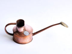 An elegant vintage Haws copper watering can, designed to be used in a greenhouse for watering seedlings or indoors for houseplants. The brass rose can be easily removed for more directional watering and is stamped "Haws Genuine". It still retains its original paper roundel that reads "The genuine Haws, Made in England", which is also stamped into the copper on the underside.