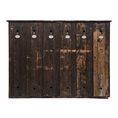 A magnificent bank of wooden lockers with original stained paint finish.  Each door is affixed with an oval aluminium numbered plate and name holder, and contains two circular air vents - top and bottom.  A grand looking and very handy storage solution for hallway, boot room or kitchen.