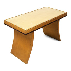 A rare and striking Art Deco occasional table that is purported to have once been part of the 1930s bedroom furniture at The Savoy Hotel, London. Finished in a satinwood veneer, the recessed top holds an inset rectangle of protective plate-glass within its frame.  Its gracefully tapered crescent-shaped legs are certainly in the style of past Art Deco furniture belonging to the hotel.