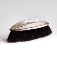 A good-looking and tidy little clothes brush with sterling silver handle monogrammed with the initials "A J S" dating to the 1920s. The elegant scooped handle is designed for ease of holding, and is hallmarked with a lion, and will fit comfortably into your bag or briefcase.