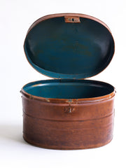 A handsome Victorian hat tin with hinged lid, carrying handle, hasp, and original pecan brown painted finish. The interior paint is also original and is a steely Prussian blue. It has a wonderful polished and buffed patina, built from its 130 years of travels.