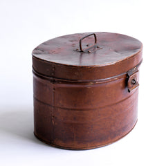 A handsome Victorian hat tin with hinged lid, carrying handle, hasp, and original pecan brown painted finish. The interior paint is also original and is a steely Prussian blue. It has a wonderful polished and buffed patina, built from its 130 years of travels.