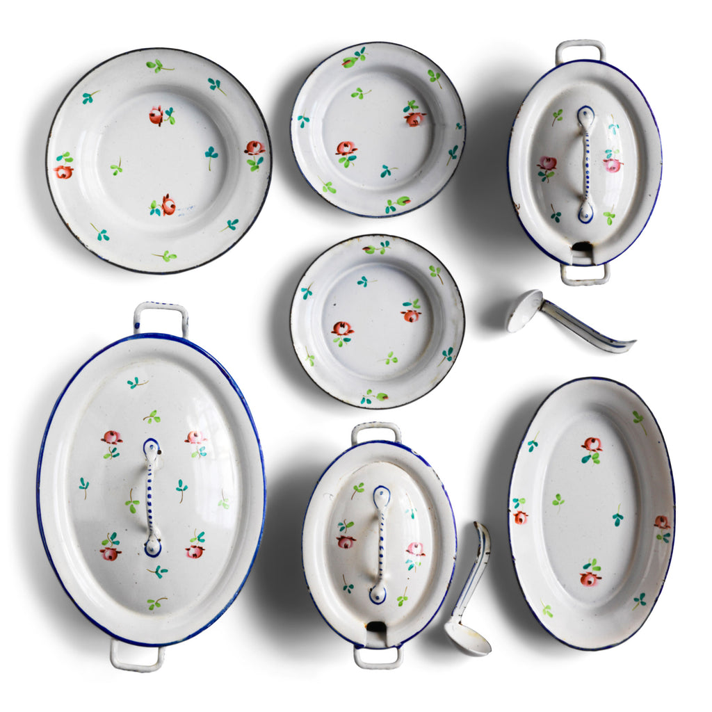 A wonderful, rare antique doll's enamel dinner service decorated with rose buds and leaf sprigs, and each piece finished with a blue trim; very much in tune with the current trend "cottage core", an aesthetic which celebrates an idealised rural life. This is part of an extensive collection of miniature enamel kitchen ware, previously owned by the late miniaturist specialist and collector extraordinaire Joan Dunk.