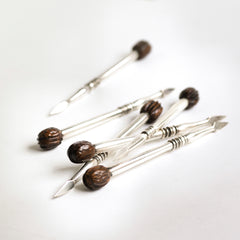 A rare set of 1930s silver-plated nut picks designed to wheedle out every last nugget of flesh from a walnut shell - always the difficult nut to dissect. They have a wonderful weight and beautifully turned, polished handles with a miniature walnut modelled in wood at the end of each.