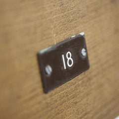 Very good-looking cricket pavilion chairs, each with a small enamel number affixed to its back (numbers 18 and 20). Each is beautifully constructed of solid beech and designed to fold flat when not in use, and so can easily be stored.