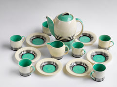 A good 1930s Art Deco Susie Cooper coffee set decorated with green and black banding. Restraint, fitness for purpose and a careful consideration for shape and pattern are Susie Cooper hallmarks, to which this rare 1930s Kestrel shape coffee set in green Tango stands testament. The Susie Cooper trademark 1930s signature leaping deer logo is on the underside of each piece, and the set includes a coffee pot, milk jug, and six coffee cans and saucers.