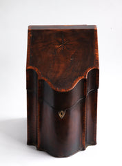 A George III mahogany veneered knife box with an elegant star inlay on the slope of its lid. The serpentine front is banded in satinwood, and it has a compass star decoration with rope cross-banded inlay applied to the underside of its lid - with a silver shield-shaped escutcheon to the lock on the front. 