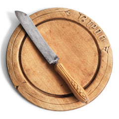 A Victorian breadboard with "Bread" carved typography and a bread knife with a wheat sheaf design carved handle.