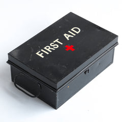 A good-looking first aid tin, the lid stencilled "First Aid" in sans serif and with a red cross. It has a pair of carrying handles and its original black enamel paint finish. 