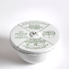 A vintage ironstone Grimwades pudding bowl with central heat funnel and fitted lid. The bowl and lid are liberally decorated with graphic typography and illustrations on how to use the Quick Cooker.