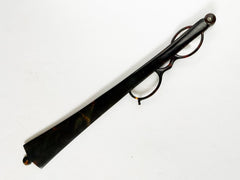 An Edwardian faux tortoiseshell lorgnette - an elegant  pair of fine oval spectacles attached to a long arm in  mock tortoiseshell.